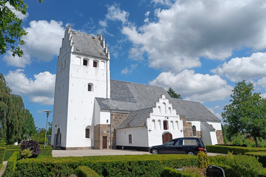 Brenderup Kirke blå himmel skyer rustvogn bedemand