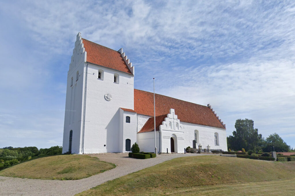 Veflinge Kirke blå himmel skyer bakker træer